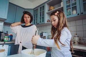 maman apprend à sa petite fille à cuisiner photo