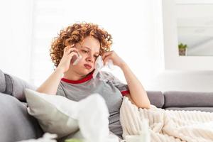 femme malade appelant le centre de santé pour une infection potentielle à coronavirus. jeune femme fiévreuse inquiète pour sa santé. photo