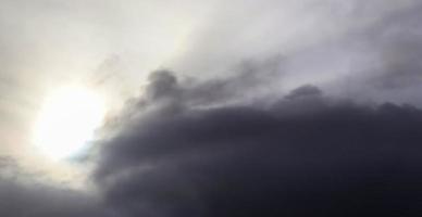 belle vue sur les rayons du soleil avec quelques reflets et nuages dans un ciel bleu photo