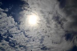 belle vue sur les rayons du soleil avec quelques reflets et nuages dans un ciel bleu photo