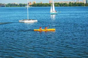 athlètes en kayak s'entraînant près de la fontaine de la rivière dans un arc-en-ciel d'éclaboussures. photo