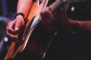 gros plan des mains d'homme jouant à la guitare acoustique. photo