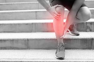 coureur touchant douloureux tordu ou cassé. entraînement d'athlète, accident de course dans les escaliers. une entorse sportive entorse cause une blessure au genou. et des douleurs aux os des jambes. photo