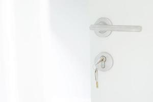 clé de maison sur porte-clés en forme de maison porte-clés en argent dans l'ouverture d'une porte. concept d'achat de logement et d'appartement d'agent immobilier. photo