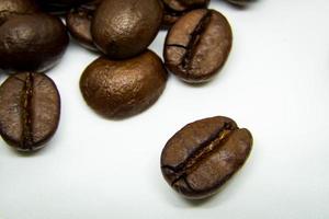 la façon dont les grains de café reposent sur un fond blanc, des grains de café élégants et délicieux et l'arôme du café du matin. photo