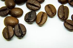 la façon dont les grains de café reposent sur un fond blanc, des grains de café élégants et délicieux et l'arôme du café du matin. photo