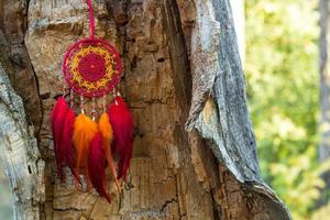 attrape-rêves fait à la main avec des fils de plumes et des cordes de perles suspendues photo