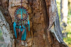 attrape-rêves fait à la main avec des fils de plumes et des cordes de perles suspendues photo