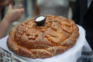 pain avec du sel. pain de tradition de mariage russe pour les mariés. petit pain cuit au four avec croûte dorée. mariage en russie en détail. photo