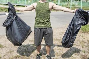 ramassage des ordures dans des sacs en plastique. protection environnementale. photo