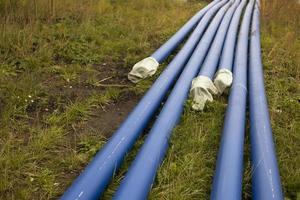 conduites d'eau bleues. les tuyaux industriels reposent sur le sol. détails de la pose de tuyaux avec du gaz. photo