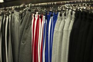 vêtements de sport sur cintres dans le magasin. vente de pantalons d'entraînement. photo