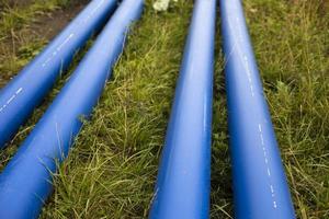 conduites d'eau bleues. les tuyaux industriels reposent sur le sol. détails de la pose de tuyaux avec du gaz. photo