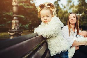 mère et deux filles se reposent sur un banc photo