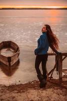 femme appréciant le temps de détente au bord du magnifique lac au lever du soleil. photo
