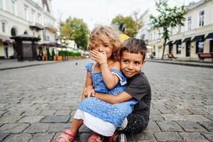 petit garçon et fille sont assis dans la rue photo