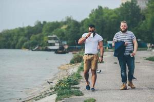 deux hommes marchent et boivent du café photo