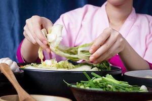 les femmes coréennes portent des hanboks traditionnels, font du kimchi. concept de cuisiner des aliments fermentés charmants et parfumés, cuisine asiatique issue de la sagesse populaire photo