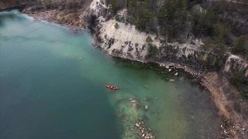 deux hommes athlétiques flottent sur un bateau rouge dans la rivière photo