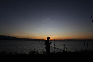 silhouette d'un peuple sur le lac photo