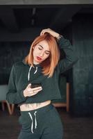 femme rousse blanche européenne tenir smartphone intérieur photo