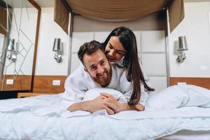 photo montrant un couple heureux se reposant dans une chambre d'hôtel