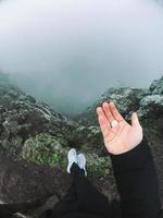 homme sur la falaise regarde le brouillard photo