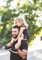 une petite fille est assise sur les épaules photo