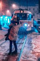 jeune couple adulte sur la ligne de tramway enneigée photo