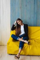 jeune femme assise sur un canapé jaune photo