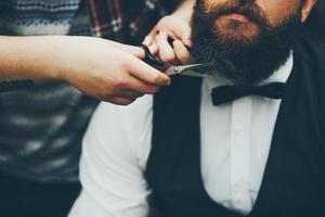 coiffeur rase un homme barbu dans une atmosphère vintage photo