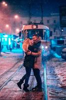 jeune couple adulte sur la ligne de tramway enneigée photo