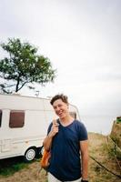 beau, jeune mec posant sur un bord de mer sauvage photo