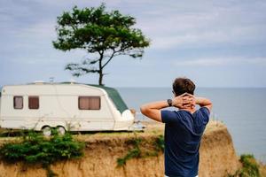 beau, jeune mec posant sur un bord de mer sauvage photo