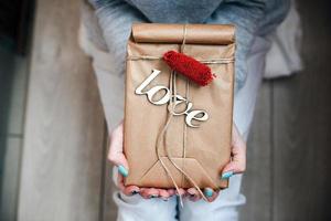 la jeune fille tient dans les mains un charmant cadeau pour son bien-aimé photo