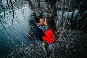 beau couple posant près d'une rivière gelée photo