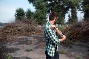 l'homme aux bottes authentiques et aux jeans selvedge sur fond de branches photo