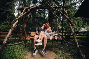 beau couple avec chien sur une balançoire photo