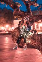 fille d'âge préscolaire assise sur une branche d'arbre photo