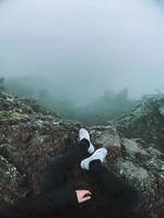 homme sur la falaise regarde le brouillard photo