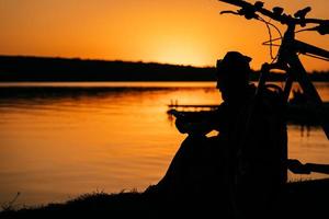 le gars se repose sur la rive du fleuve. photo