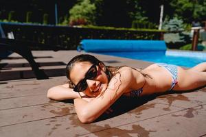 heureuse adolescente se trouve au bord de la piscine photo