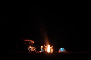 amis heureux se reposer ensemble autour d'un feu de camp photo