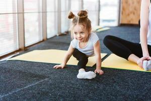 une petite fille répète des exercices pour sa mère photo