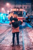 jeune couple adulte sur la ligne de tramway enneigée photo