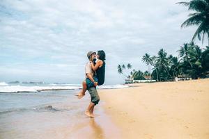 un mec et une fille s'embrassent sur la plage photo