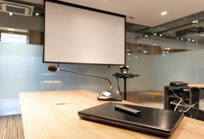 ordinateur portable et microphone avec fond d'écran de projecteur dans la salle de réunion photo