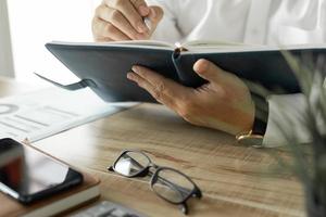 homme d'affaires écrivant un plan d'investissement d'entreprise, homme portant une chemise blanche travaillant sur le bureau au bureau photo