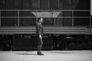 un homme vêtu de jeans sur le fond du train et de la gare photo