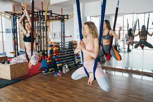 les jeunes filles font du yoga aérien dans la salle de gym photo